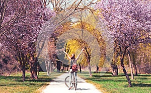 Happy woman on bicycle in beautiful park
