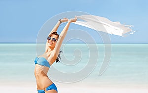 Happy woman in bikini and sunglasses on a beach