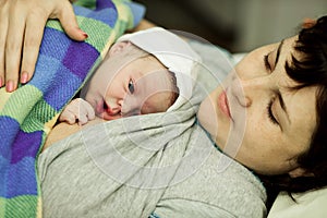 Happy woman after birth with a newborn baby
