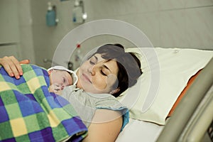 Happy woman after birth with a newborn baby