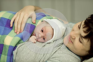 Happy woman after birth with a newborn baby