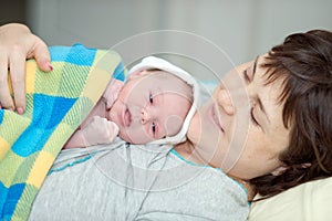 Happy woman after birth with a newborn baby