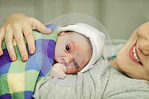 Happy woman after birth with a newborn baby