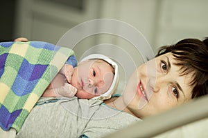 Happy woman after birth with a newborn baby