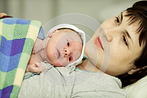 Happy woman after birth with a newborn baby