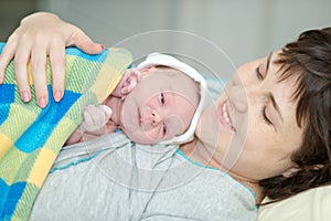 Happy woman after birth with a newborn baby