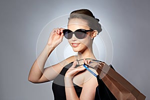 Happy woman in black sunglasses with shopping bags