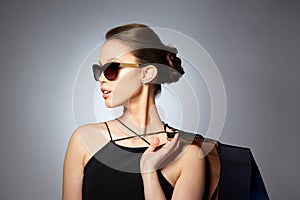 Happy woman in black sunglasses with shopping bags