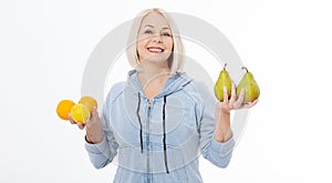 Happy woman with blond hair and beautiful smile holds two oranges, lemon and a pears in her hands for a healthy diet