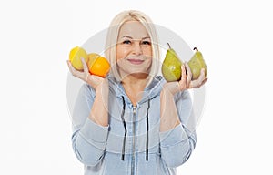 Happy woman with blond hair and beautiful smile holds two oranges, lemon and a pears in her hands for a healthy diet with