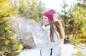 Feliz una mujer soplo sobre el la nieve afuera en soleado 