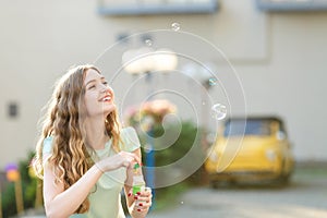 Happy woman blowing soap bubbles