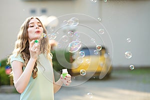 Happy woman blowing soap bubbles