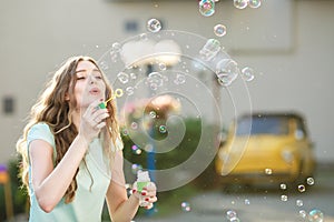 Happy woman blowing soap bubbles