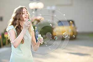 Happy woman blowing soap bubbles