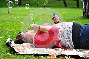 Happy woman blowing soap bubbles