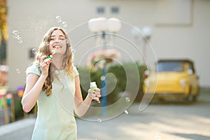 Happy woman blowing soap bubbles. focus on soap bubbles