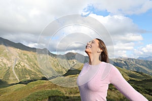 Happy woman breathing fresh air alone in nature