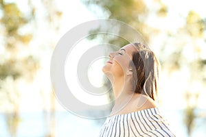 Happy woman breathing fresh air outside