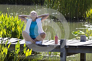 Happy woman breathing for openness and healthy wellbeing over water photo