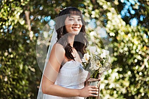Happy woman, bride and bouquet of flowers for wedding, marriage or ceremony in outdoor nature. Female person with smile
