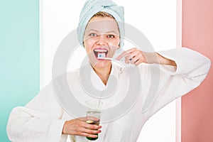 Happy woman brushing teeth. Girl with toothbrush and glass of water. Oral hygiene. Cleaning teeth.