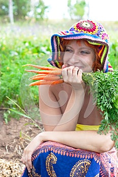 Happy woman with bunch of carrots