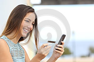 Happy woman buying online with a smart phone