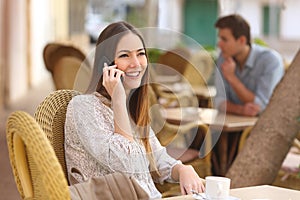 Happy woman calling on the phone in a restaurant photo