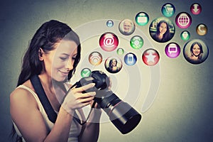 Happy woman with camera models social media icons flying out of screen