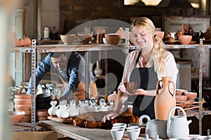 Happy woman carrying ceramic vessels