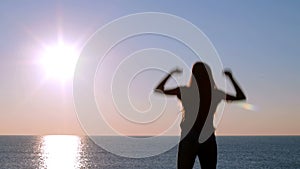 Happy woman celebrating sunrise on the beach