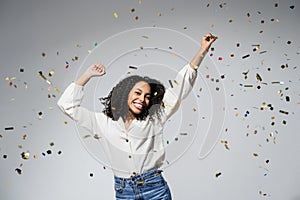 Happy woman at celebration party with confetti falling everywhere on her