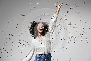 Happy woman at celebration party with confetti falling everywhere on her, Birthday or New Year eve celebrating concept.