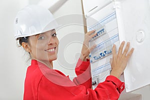 happy woman checking fuseboard