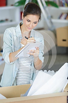 happy woman checking stuff in cardboard box