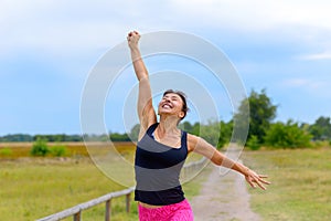Happy woman cheering and celebrating after working out jogging