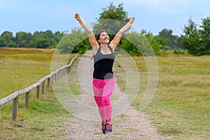 Happy woman cheering and celebrating after working out jogging