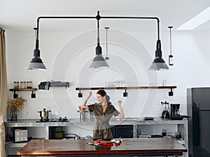 Happy woman chef smile with teeth in Stylish kitchen interior with natural elements in wood and stone design with fresh