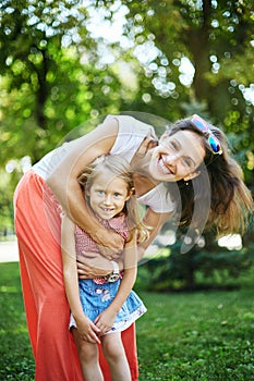 Happy woman and child in the blooming spring garden.Mothers day holiday concept