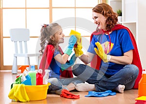 Happy woman with child cleaning room and having fun playing at home. Family housework conception.