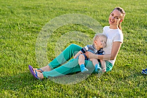 Happy woman and child having fun outdoor on meadow