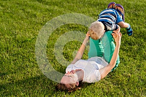 Happy woman and child having fun outdoor on meadow