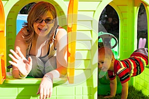 Happy woman and child in playhouse