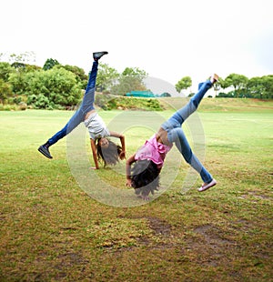 Happy woman, children and friends in cartwheel on green grass or field together for fun day at the park. Young girls