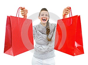 Happy woman in christmas hat showing christmas shopping bags