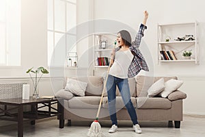 Happy woman cleaning home with mop and having fun