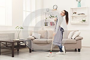 Happy woman cleaning home with mop and having fun