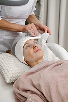 Happy woman, cleaning skin procedure in aesthetic clinic