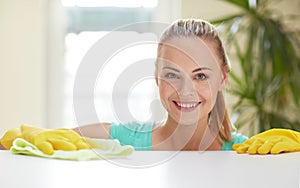 Happy woman cleaning table at home kitchen
